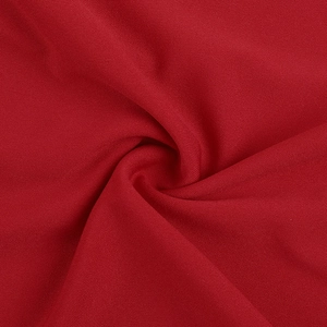 Detailed macro shot of deep red high-density jersey fabric with elegant spiral draping