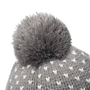 Detailed view of grey knitted beanie top featuring white heart patterns and a large pom-pom