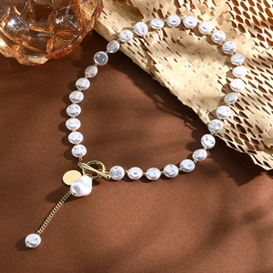 Baroque pearl necklace with gold OT toggle clasp and pendant detail on a warm aesthetic set