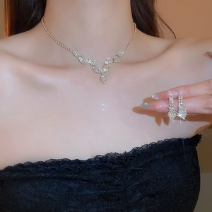 Detail of silver rhinestone necklace and earring set with elegant leaf design on model