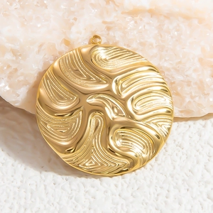 Macro detail of golden circular pendant with ripple texture on white rock surface