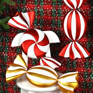 Red and gold electroplated candy-shaped Christmas ornaments on festive tablecloth
