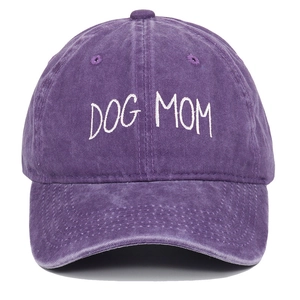 Detailed view of DOG MOM embroidery on washed purple cotton baseball cap fabric