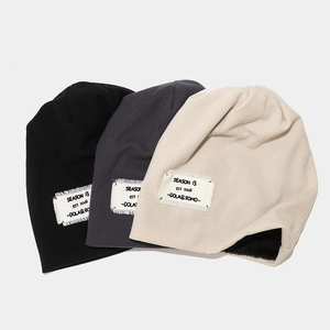Three knitted beanies in black, grey, and beige with warm plush lining and vintage patches