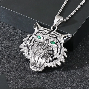 Macro shot of silver tiger head pendant with green eyes and sparkling rhinestones