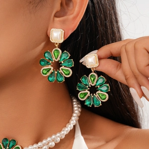 Close-up of vintage baroque pearl necklace with green crystal flower pendant