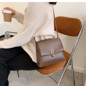 Sac à bandoulière rectangulaire marron avec fermoir en U doré en décor de mode de vie