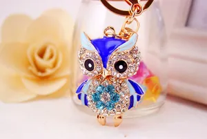 Close-up of owl keychain with blue enamel and sparkling crystals on golden metal