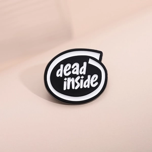 Vue détaillée du pin's émaillé blanc avec lettrage noir dead inside et bordure
