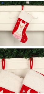 Detail of red Christmas stocking featuring alpaca embroidery and plush white cuff decoration