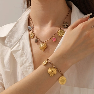 Detail of woven chain necklace and bracelet set with tiger and heart pendants
