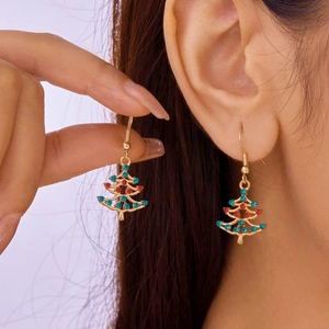 Close-up of Christmas tree earrings with red and blue rhinestones on gold metal