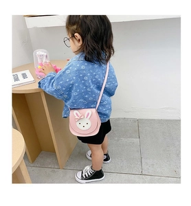 Detailed view of pink crossbody bag with a 3D bunny face on a child model's shoulder