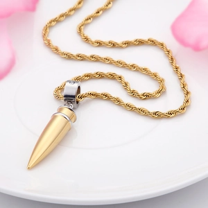 Macro shot of a gold and silver bullet pendant necklace with a stylish twisted rope chain