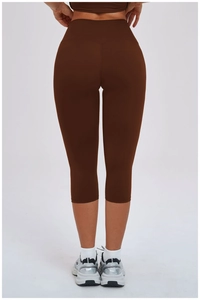 Detailed back view of high-waisted dark brown yoga capri pants with V-shaped lifting seams
