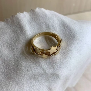 French vintage gold star ring with zircon accents on white textured fabric