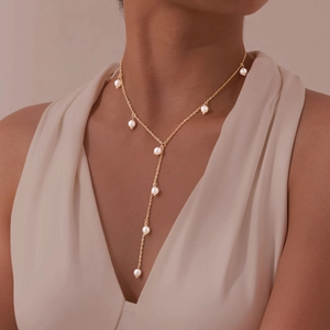 Dettaglio della catena placcata oro 18K con eleganti nappe di perle bianche sulla collana