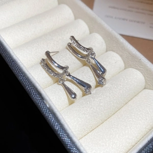 Detailed view of silver zircon water drop earrings placed in a white velvet jewelry box