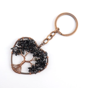Macro shot of bronze Tree of Life pendant with black natural stones on a keyring