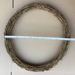 Nahaufnahme eines 50cm Weidenkranzes aus Naturholz mit Maßband auf Kartonhintergrund