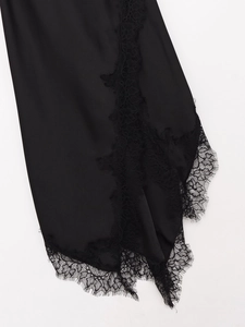 Détail de la robe en satin noir avec bordure en dentelle de cils délicate sur l'ourlet