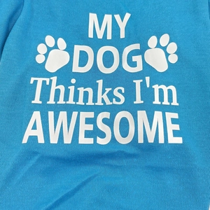 Close-up of sky blue dog vest with My Dog Thinks I'm Awesome slogan and paw prints