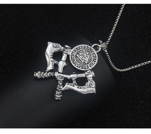 Detailed close-up of a silver Viking axe and shield pendant on textured black leather
