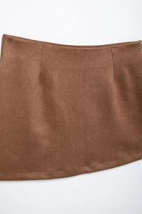 Detail of brown faux suede skirt showing refined texture and waist stitching details