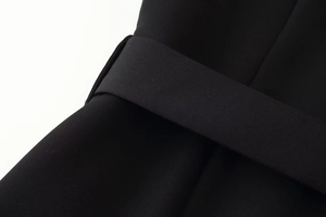 Close-up of a wide black woven belt and fabric texture on a minimalist dress detail