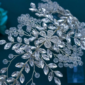 Detail of silver bridal headband with crystal beads and intricate rhinestone flowers
