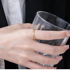 Detail of 18K gold-plated honeycomb ring on hand with elegant professional outfit
