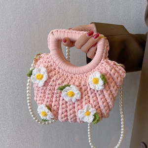 Pink handmade crochet shell bag with white floral accents and pearl shoulder strap