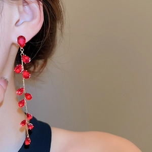 Detail of red water drop zircon tassel earrings showing crystal facets and gold plating