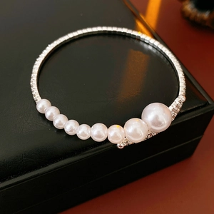 Detail of silver rhinestone chain bracelet with gradient white pearls on black leather box