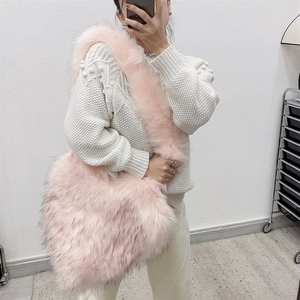 Detailed view of pink faux fur crossbody heart bag with soft plush shoulder strap