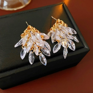 Détail de boucles d'oreilles en argent et zircon sur texture en cuir noir élégante