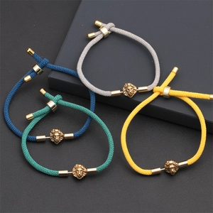 Detail of woven bracelets in four colors featuring adjustable alloy lion head charms