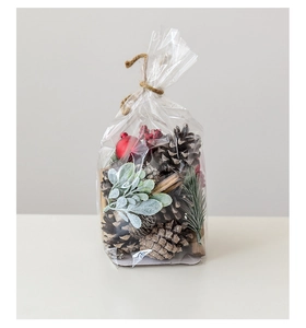 Detailed view of Christmas DIY pine cones with red berries in rustic gift packaging