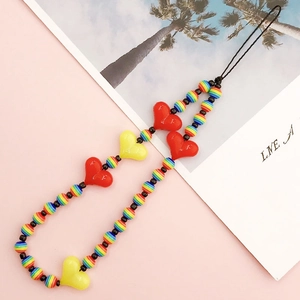 Detailed view of colorful acrylic heart beads and rainbow pearls on a phone lanyard