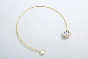 Macro shot of gold stainless steel choker with large sparkling cubic zirconia detail