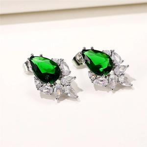 Macro detail of pear-shaped emerald green zircon earrings with marquise diamond accents