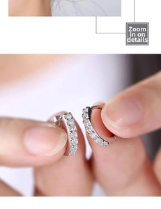 Macro shot of silver pavé huggie earrings with small round clear cubic zirconia stones