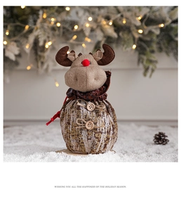 Detail of reindeer Christmas gift bag with wood buttons and bark texture on a festive base