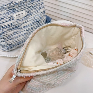 Detailed view of tweed cosmetic bags showing large interior capacity and woven texture