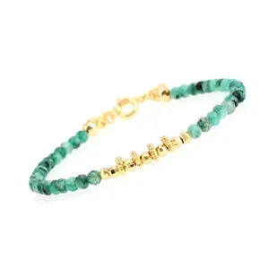 Close-up of green faceted beads and gold-plated spacers on a fine adjustable bracelet