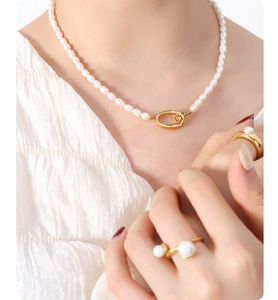 Detail showing freshwater pearl necklace with gold oval clasp and matching rings