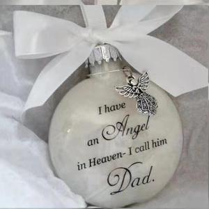 Close-up of commemorative feather ball ornament with Dad engraving and silver angel charm