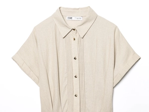 Close-up of linen shirt collar with gold buttons and pleated front details