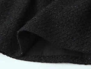 Detail of black tweed fabric texture with shimmering fibers and smooth lining