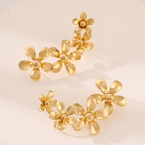 Detail van minimalistische gouden bloem oorklimmers met een ontwerp van kleine bloemblaadjes